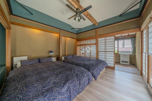 a bedroom with a bed and a ceiling fan at 草津温泉湯畑 徒歩圏内 &温泉街を大勢で遊びたい & 癒されたい in Kusatsu