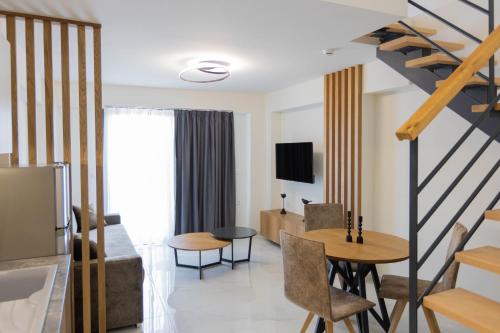 a living room with a staircase and a dining room at Calma Luxury Suites in Paralia Dionysiou
