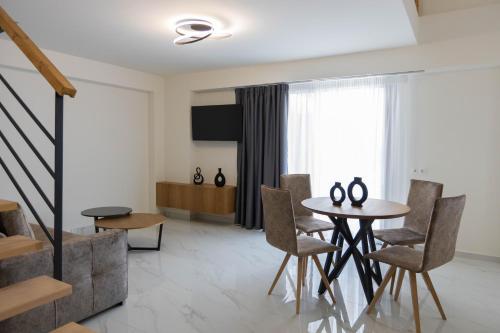 a living room with a table and chairs at Calma Luxury Suites in Paralia Dionysiou