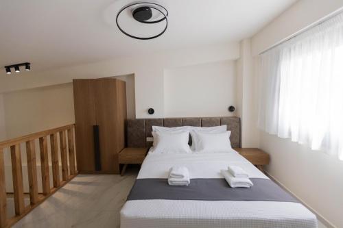 a bedroom with a bed with white towels on it at Calma Luxury Suites in Paralia Dionysiou