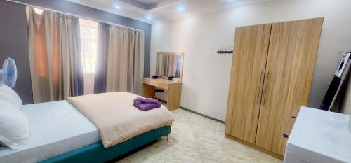 a bedroom with a bed and a wooden cabinet at lucky villas in Trou aux Biches