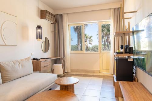 a living room with a couch and a window at Achilleas Beach Hotel Adults Only in Mastichari