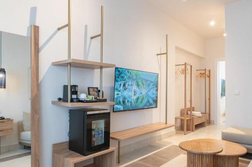 a living room with a fireplace and a tv at Achilleas Beach Hotel Adults Only in Mastichari