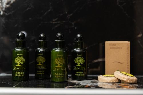 four bottles of olive fires sitting next to a box at Calma Luxury Suites in Paralia Dionysiou