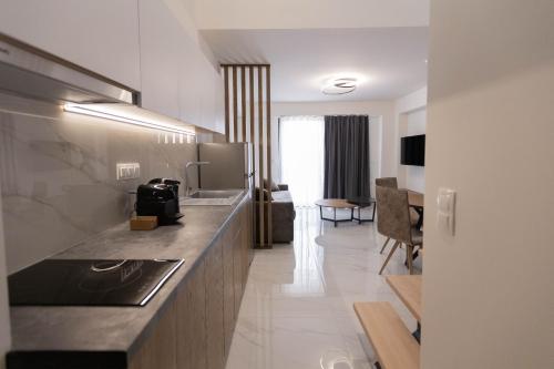 a kitchen with a counter and a living room at Calma Luxury Suites in Paralia Dionysiou