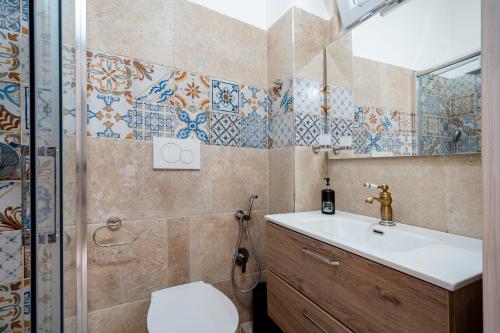 a bathroom with a toilet and a sink and a shower at Dimora Don Gabriele in Mola di Bari