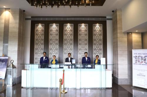 a group of men sitting at a table in a lobby at Efcee Sarovar Premiere Bhavnagar in Bhavnagar