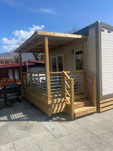a house with a deck with a roof at Camping-Village del Sole in Cannobio