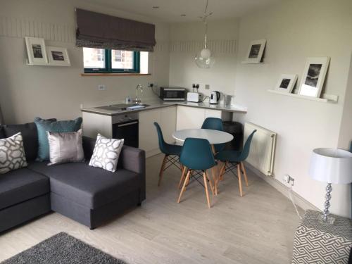 a living room with a couch and a table and chairs at Penrith Retreats in Penrith
