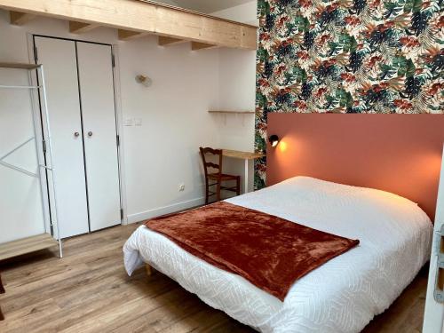 a bedroom with a bed with a blanket on it at Gite La Grange Hulotte in Chaillé-les-Marais