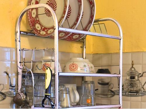 a kitchen shelf with plates and dishes on it at Northern Suite Home in Pokhara