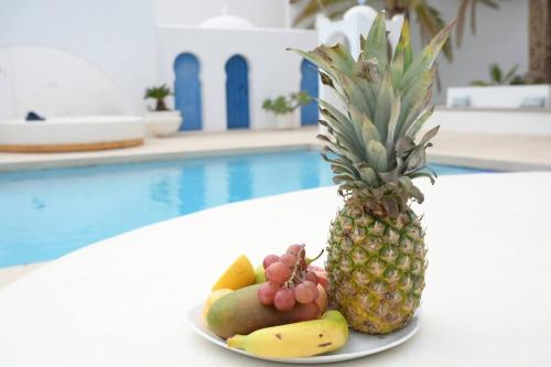a plate of fruit on a table next to a pool at Riad Salt Pool Bliss Apartamentos in Torremolinos