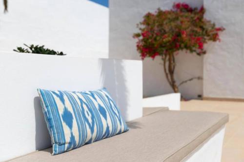 a pillow sitting on a bench in a room with flowers at Riad Salt Pool Bliss Apartamentos in Torremolinos