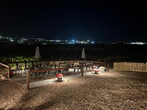 a group of tables with chairs and umbrellas at night at Golden moments Luxury Stone Villas A in Mesaria