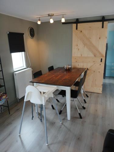a dining room table with chairs and a barn door at Ruim en rustig chalet in Nationaal park de Drentsche Aa max 5 prs in Anloo