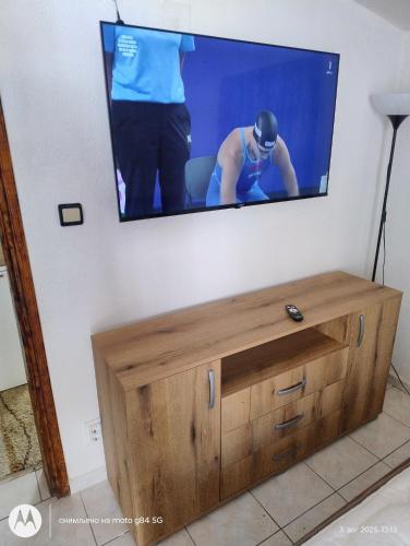 a flat screen tv hanging on a wall at Apartman V,P in Sutomore