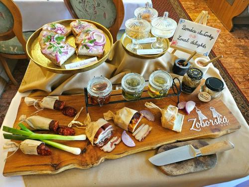 a table with sandwiches and other foods on a cutting board at Penzión Wellness & Restaurant Zoborská, free parking in Nitra