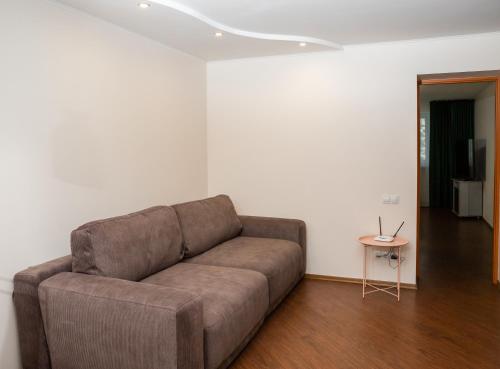 a living room with a brown couch and a table at Lotos for You Apartments in Mykolaiv