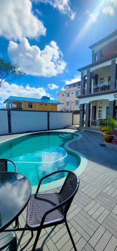 a swimming pool with a table and chairs on a patio at lucky villas in Trou aux Biches