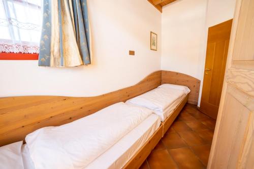 a small room with a bed with white sheets at Residence Derby Club in Folgaria
