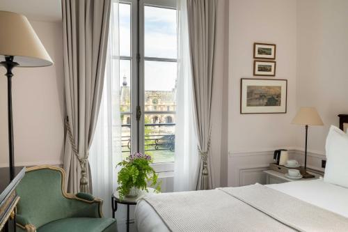 a hotel room with a bed and a window at Hotel Du Quai Voltaire in Paris