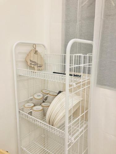 a white shelf with bowls and plates on it at Selah Nordic Guest house, with Wi-Fi, & Netflix in Palo