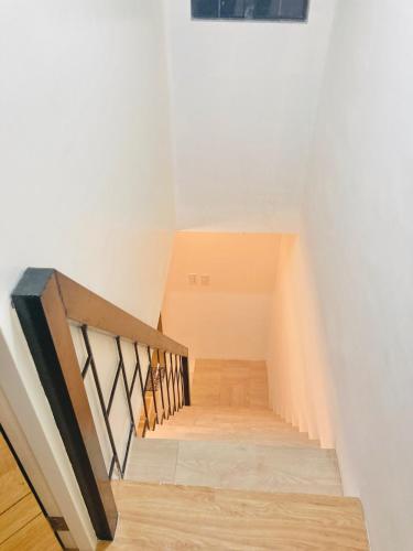 a staircase with white walls and wooden floors at Selah Nordic Guest house, with Wi-Fi, & Netflix in Palo