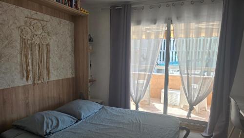 - une chambre avec un lit en face d'une fenêtre dans l'établissement Appartement 3P avec garage proche aéroport, tramway et avec toutes commodités!, à Nice