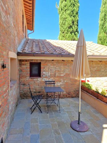 a patio with a table and an umbrella at Borgo Melograno in Chiusi