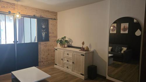 un salon avec un miroir et une commode avec une plante dans l'établissement Appartement 3P avec garage proche aéroport, tramway et avec toutes commodités!, à Nice