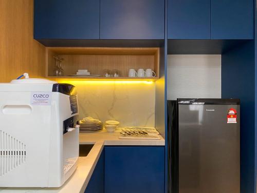 a kitchen with blue cabinets and a refrigerator at TROVE Johor Bahru in Johor Bahru
