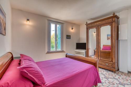 a bedroom with a pink bed and a window at Gîte A La Bonne Franck'ette in Aspiran