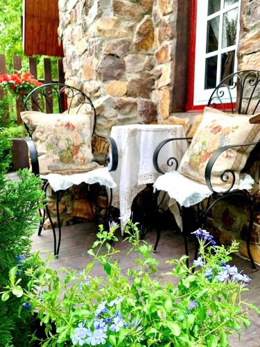 two chairs and a table in front of a building at Khu nghỉ dưỡng Ba Hạt Dẻ in Sóc Sơn
