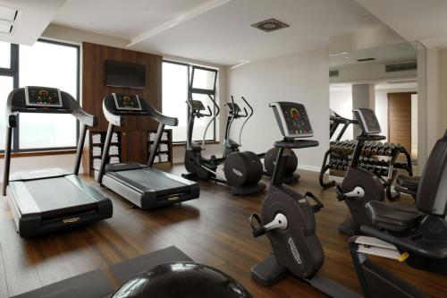 a gym with treadmills and ellipticals in a room at Courtyard by Marriott Sarajevo in Sarajevo