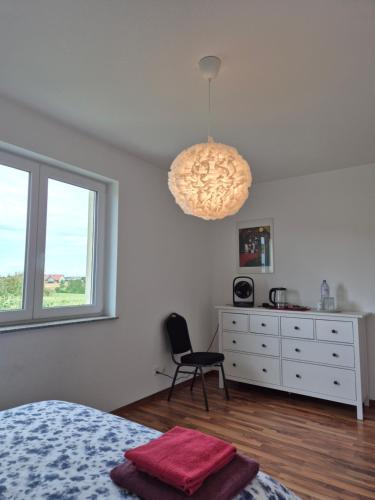 a bedroom with a bed and a chair and a chandelier at JM Swiss Space in Langrickenbach