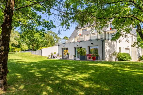 a house with a green lawn in front of it at Kerwall - Maison d'hôtes in Malville