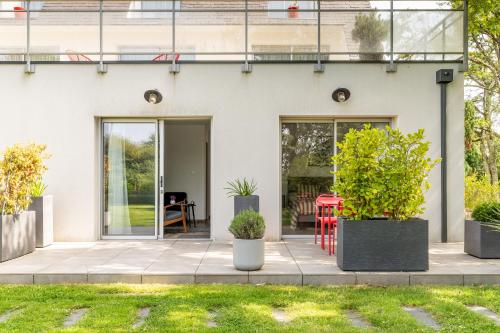 a white house with plants in front of it at Kerwall - Maison d'hôtes in Malville