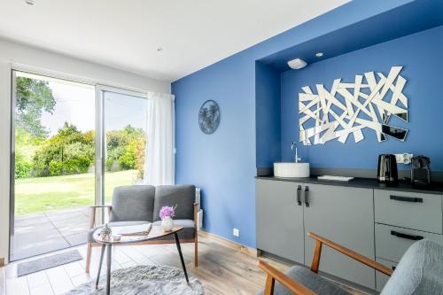 a living room with blue walls and a table and chairs at Kerwall - Maison d'hôtes in Malville