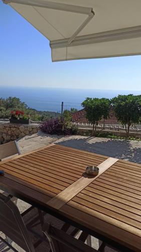 a wooden picnic table with a view of the ocean at Sun Meets Sea in Athanion