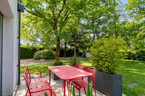 a red table and chairs on a patio at Kerwall - Maison d'hôtes in Malville