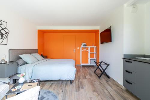 a bedroom with a bed with an orange headboard at Kerwall - Maison d'hôtes in Malville