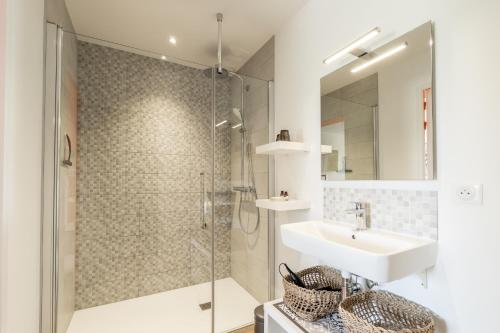 a bathroom with a glass shower and a sink at Kerwall - Maison d'hôtes in Malville