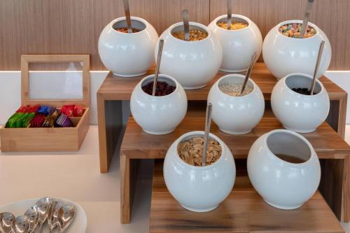 Un grupo de cuencos blancos sobre una mesa con comida. en AC Hotel By Marriott Santa Marta, en Santa Marta