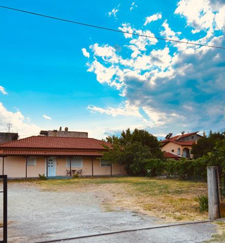 a house with a red roof under a cloudy sky at Vira Apartment in Pherrai