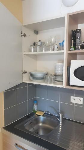 a kitchen counter with a sink and a microwave at Terrasses de Labrau - piscine in Allos