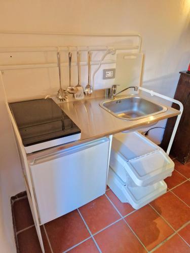 a small kitchen with a sink and a refrigerator at Borgo Melograno in Chiusi