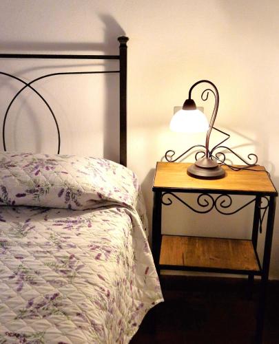 a lamp on a nightstand next to a bed at Borgo Melograno in Chiusi