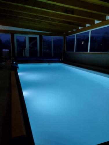 una piscina con iluminación azul en una casa en Chalupa 66 - Bukovka, en Červená Voda