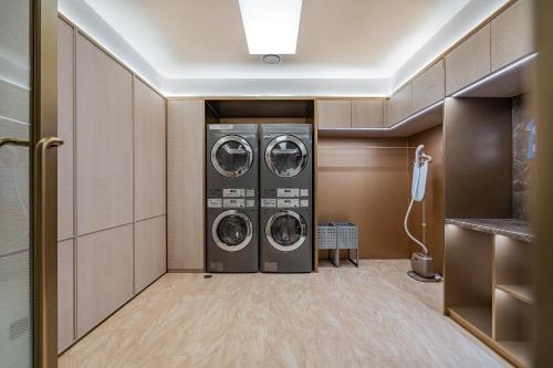 a laundry room with three washing machines in it at Hanting Hotel Beijing Zhongguancun Xueyuan Bridge Subway Station in Beijing