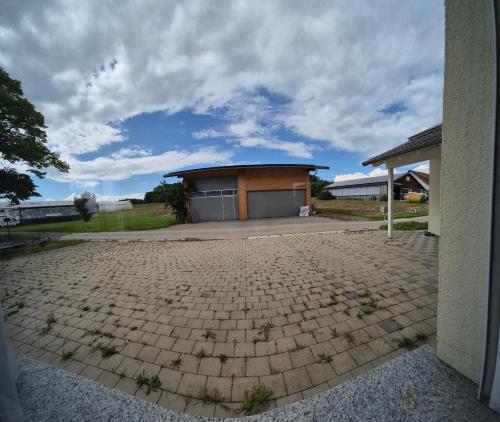 a building with a garage with a brick driveway at JM Swiss Space in Langrickenbach